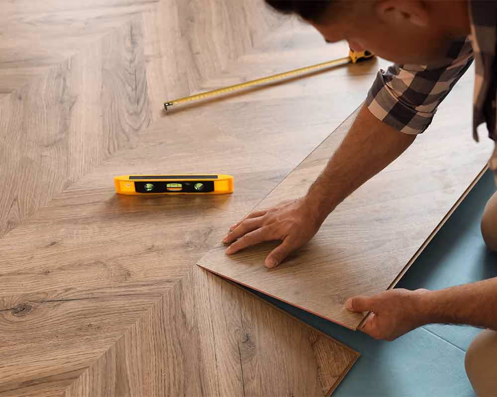 Professional hardwood floor installation with wood planks being laid