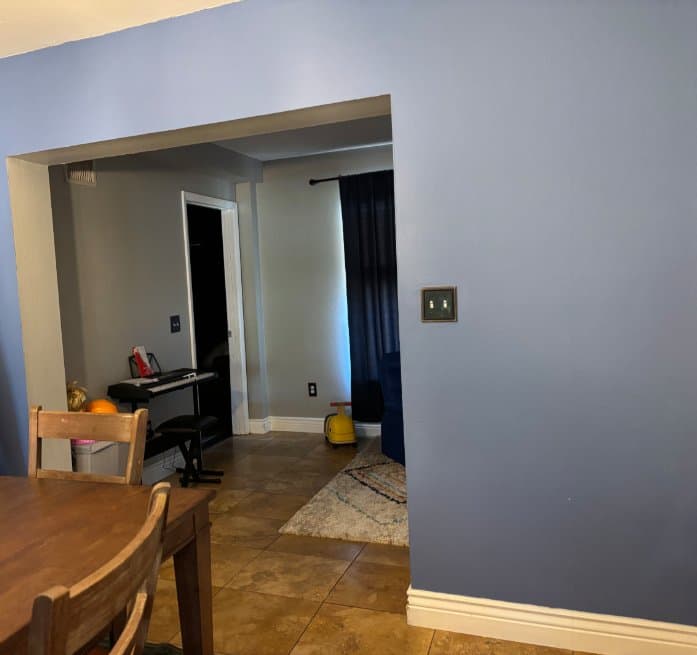 Plain blue painted wall in dining room before accent wall installation