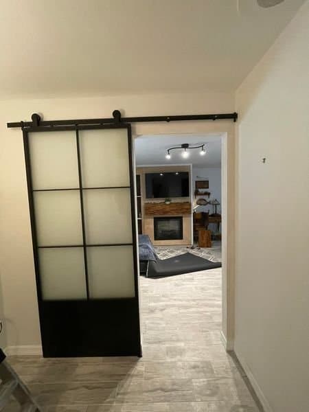 Modern black-frame frosted glass barn door installed on sliding track