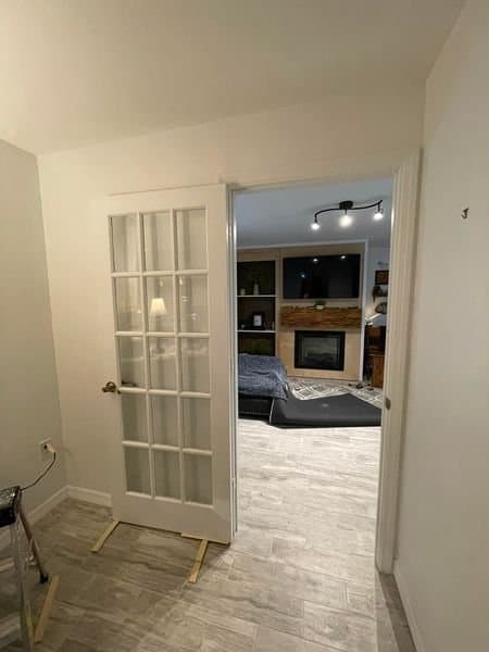 Standard white French door in hallway before barn door upgrade