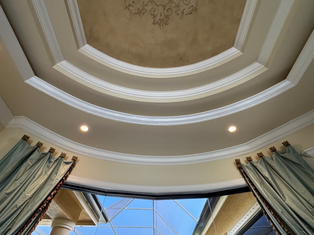 Seamlessly repaired crown molding on ornate tray ceiling with decorative faux finish