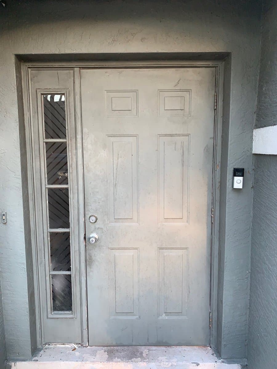 Old weathered front door with broken sidelight window