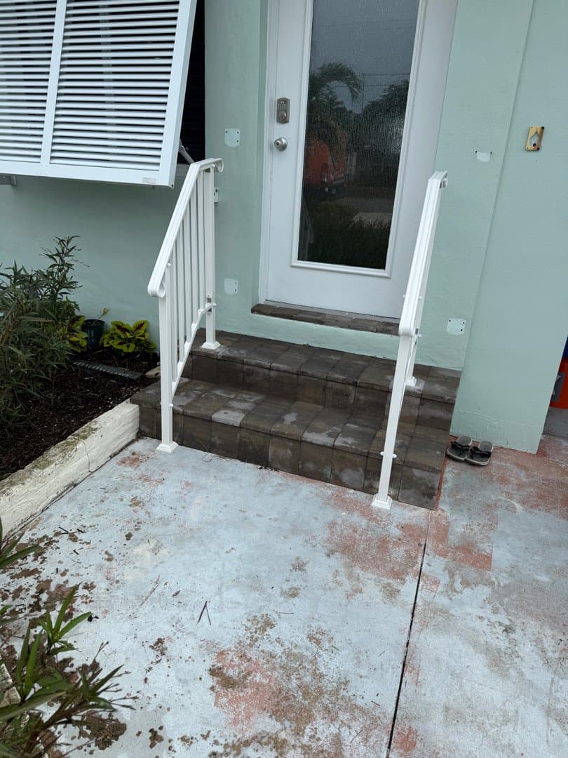 White aluminum handrails installed on both sides of entry steps