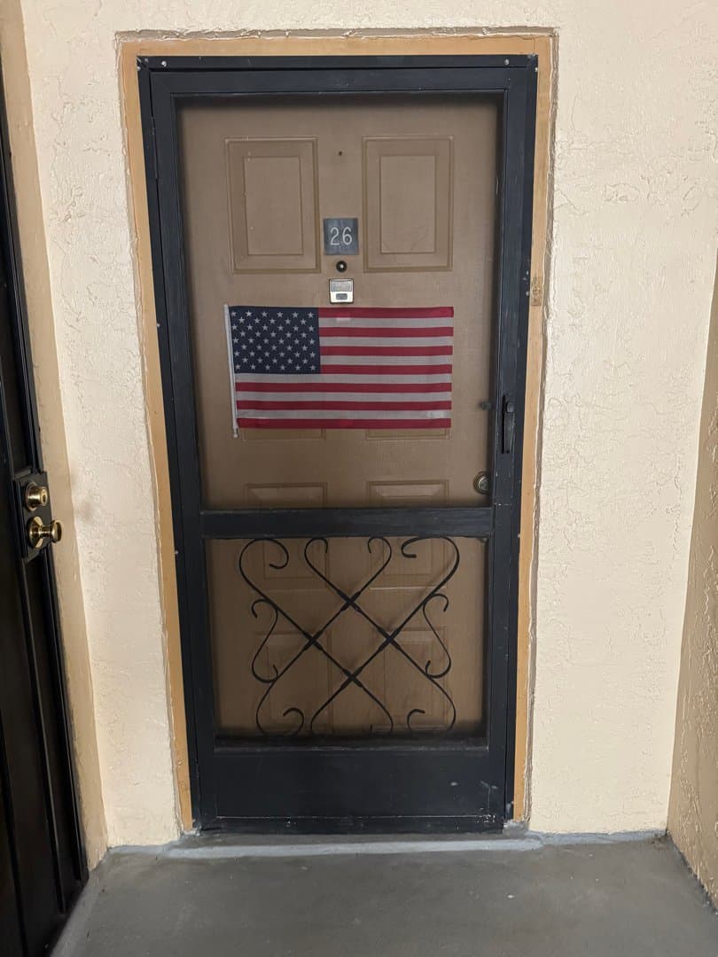 Old dark screen door with decorative scrollwork